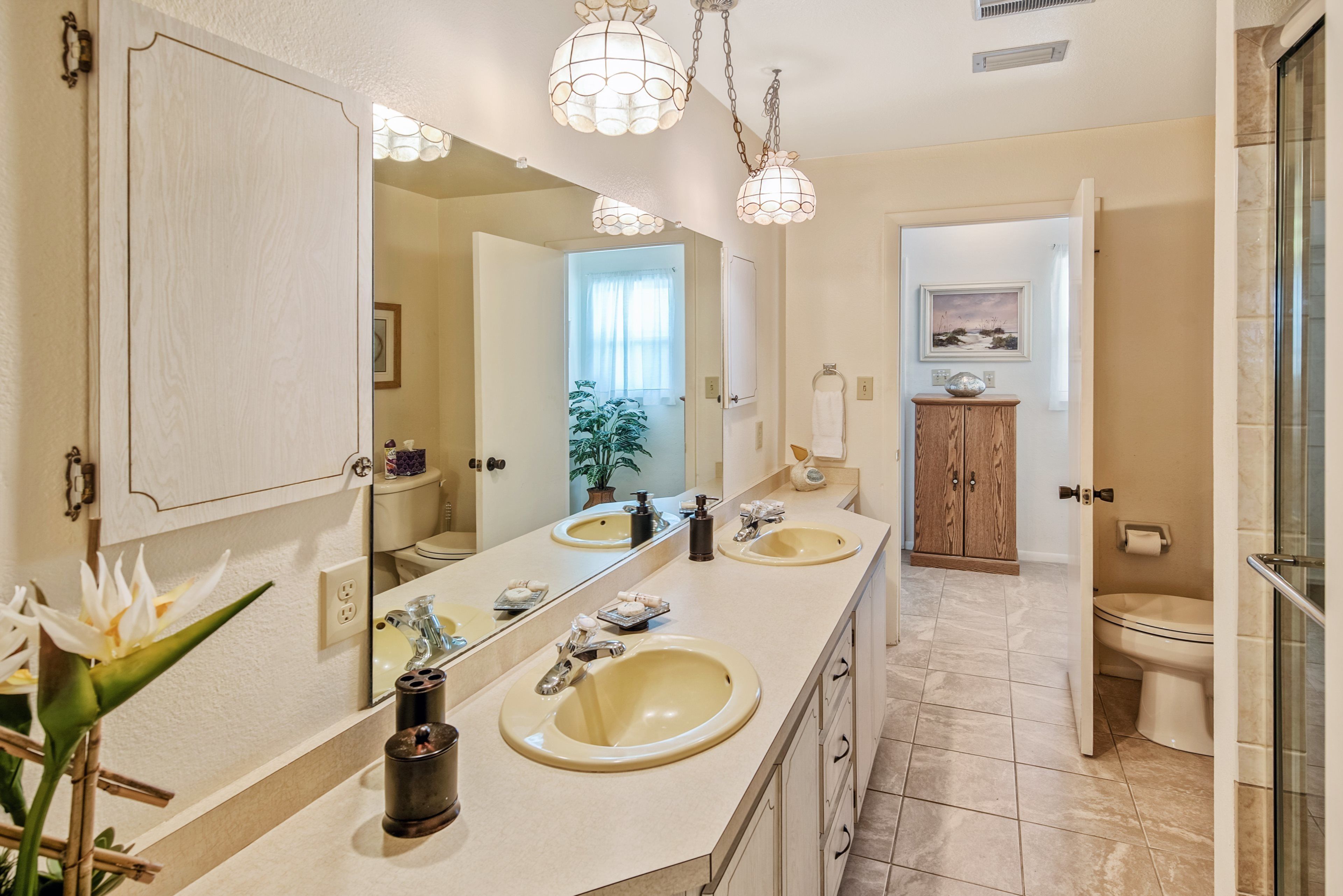 A bathroom with two sinks, a large mirror, and a shower area.
