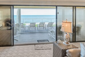A balcony with a view of the ocean, furnished with chairs and a table. - Bonita Beach 27050 (Bonita Springs)