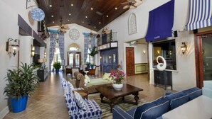 A spacious lobby with a high ceiling, patterned curtains, and a central seating area with a sofa and armchairs. - Paradise Palms 8965 Candy (Kissimmee)