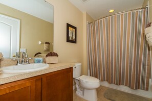 A bathroom with a sink, toilet, and shower curtain.