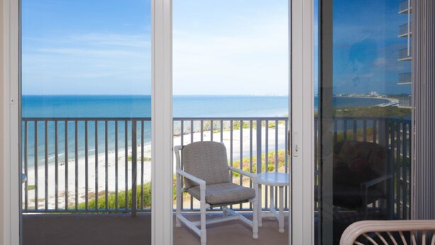 Un balcon avec vue sur la plage et l’océan.