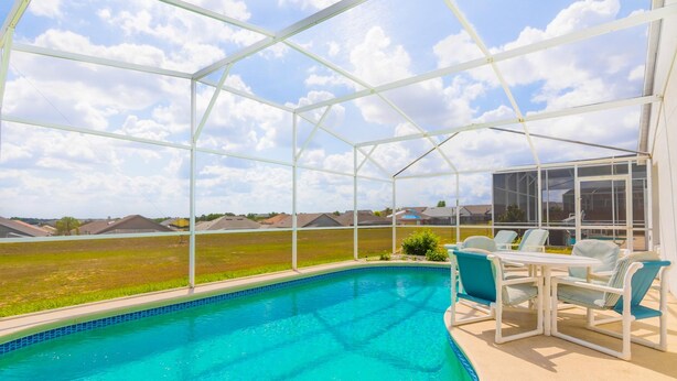 A covered swimming pool with a clear view of the surrounding landscape. - The Palms at Lake Davenport 647 (Davenport)