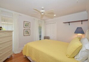 A bedroom with a bed, a dresser, a ceiling fan, and framed pictures on the wall. - Bonita Beach 5731 (Bonita Springs)
