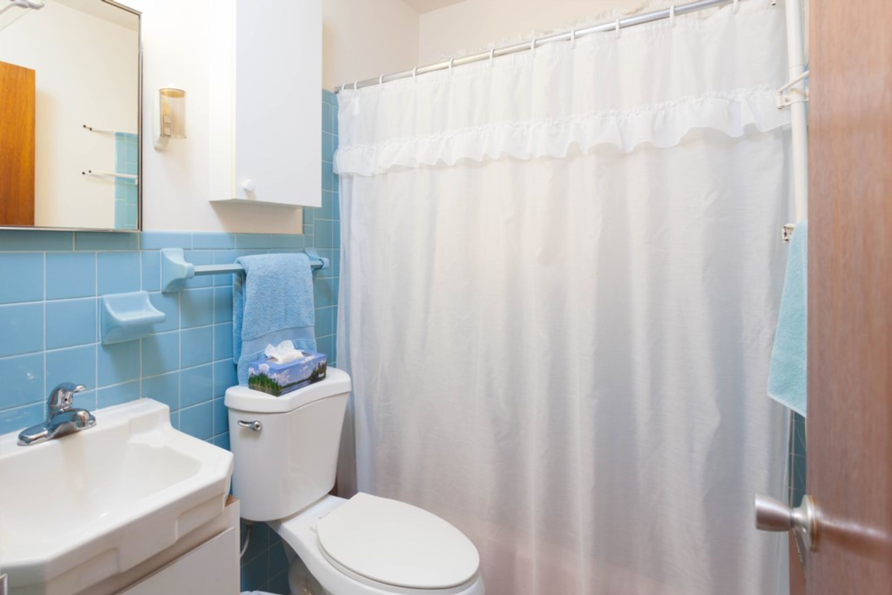 A bathroom with a white toilet, a sink, and a shower curtain.
