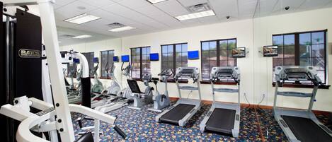 A gym with treadmills, elliptical machines, and weight equipment.