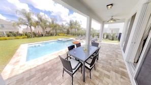 A covered patio with a pool, outdoor furniture, and a view of the surrounding neighborhood. - Encore Resort at Reunion 7705 (Kissimmee)
