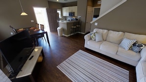 A living room with a piano, a sofa, and a kitchen in the background. - West Lucaya 8996 (Kissimmee)