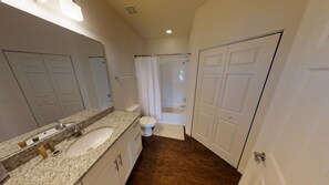 A bathroom with a double sink, toilet, and shower. - West Lucaya 8996 (Kissimmee)