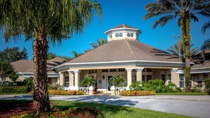 A hotel with a central courtyard, palm trees, and a well-maintained lawn.