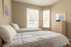 A bedroom with two beds, a dresser, and two windows. - Windsor Palms 8100 - 101 (Kissimmee)