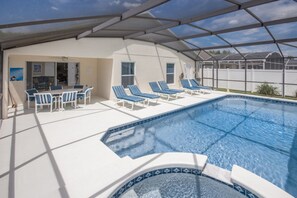 A covered swimming pool with lounge chairs and a hot tub area. - Clear Creek 941 (Clermont)
