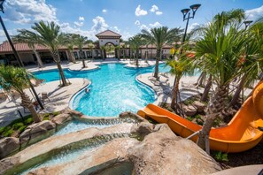 A large outdoor swimming pool with a water slide, surrounded by palm trees and lounge chairs. - Solterra 4043 (Davenport)