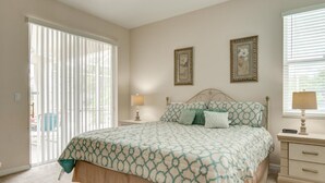 A bedroom with a bed, a nightstand, a lamp, and a window with blinds. - Highlands Reserve Golf & Country Club 447 (Davenport)