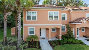 A two-story house with a front porch, a driveway, and a well-maintained lawn.