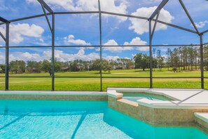 A swimming pool with a view of a golf course through a covered area. - Highlands Reserve Golf & Country Club 322 (Davenport)