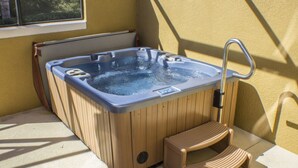 A hot tub with a wooden exterior, a built-in seat, and a metal faucet. - Encantada Resort 3076 (Kissimmee)