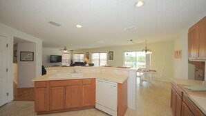 A spacious kitchen with wooden cabinets, a dishwasher, and a large island. - Four Corners 908 (Davenport)