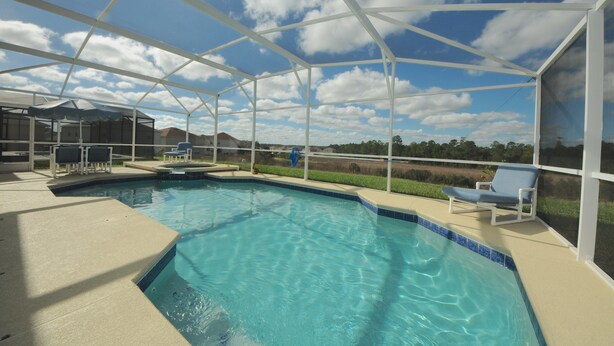 A covered swimming pool with a clear view of the sky and surrounding landscape. - Four Corners 908 (Davenport)