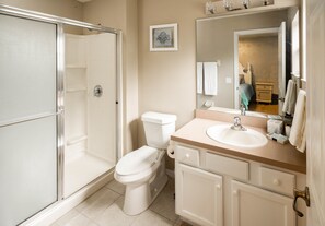 A bathroom with a shower, toilet, sink, and vanity. - Bella Vida 4536 (Kissimmee)