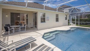 A covered outdoor swimming pool area with lounge chairs and a table. - Highlands Reserve Golf & Country Club 349 (Davenport)