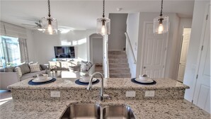 A kitchen with granite countertops, stainless steel sink, and pendant lighting. - Golden Palms Vacation Resort 2588 (Kissimmee)