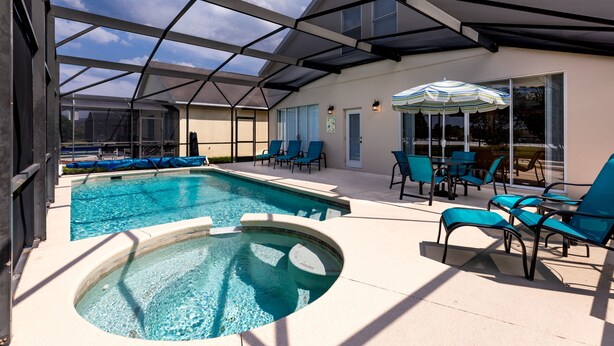 Un espace piscine doté d’un jacuzzi, de chaises longues et de parasols.