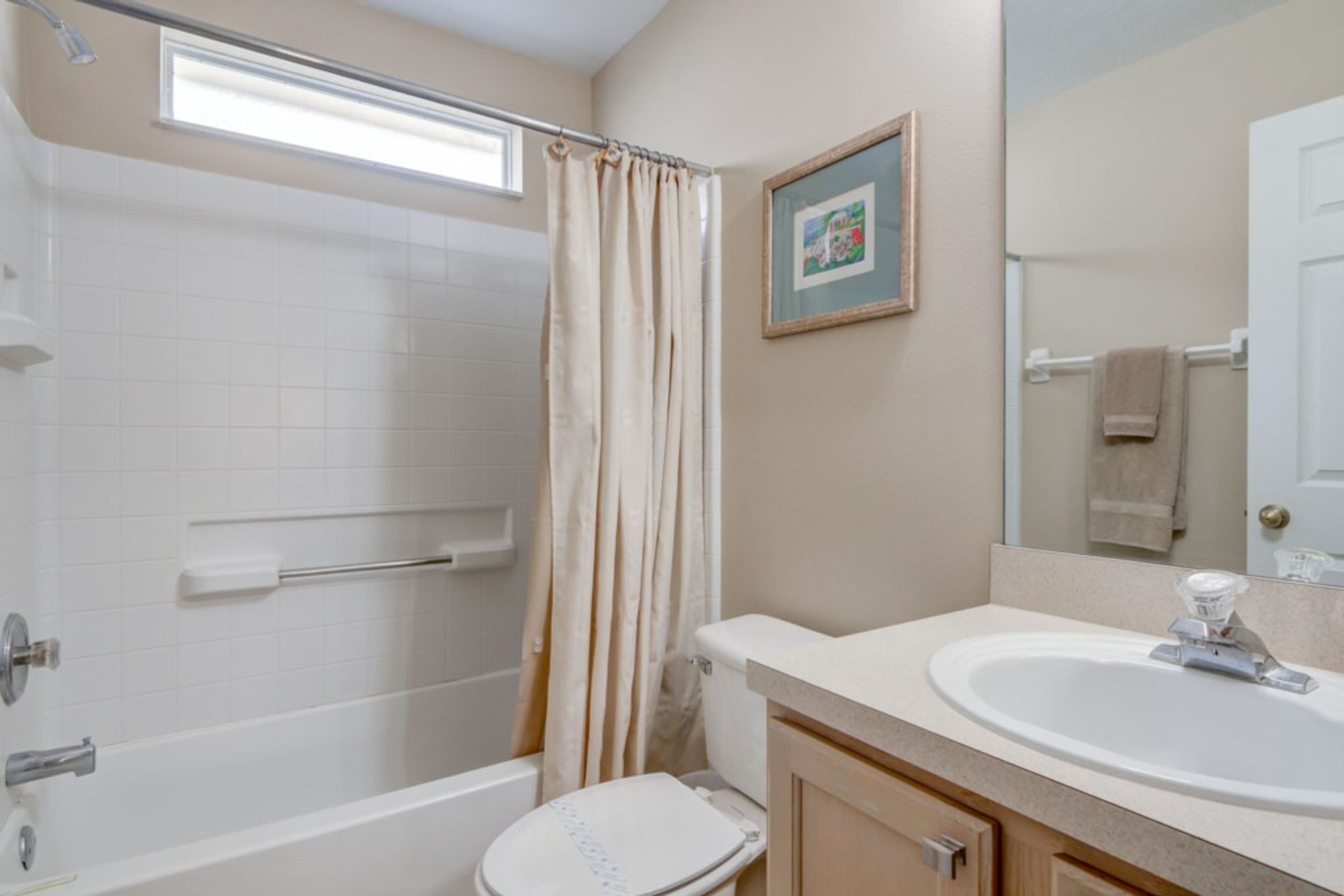 A bathroom with a bathtub, toilet, and sink.