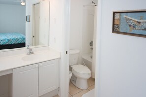 A bathroom with a white sink, mirror, and toilet. - Club Cortile 2730b (Kissimmee)
