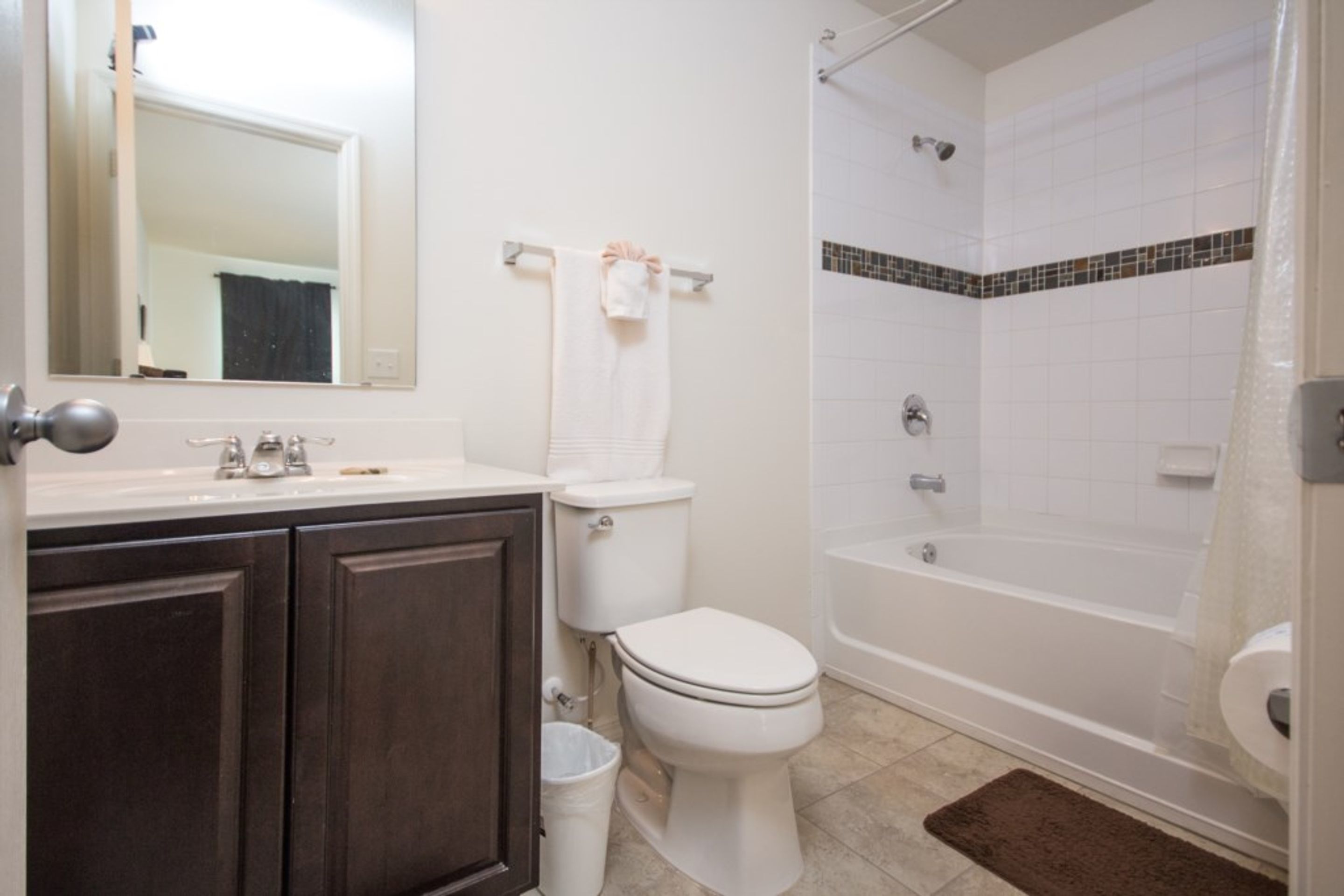 Une salle de bain comprenant des toilettes, un lavabo, un miroir et une baignoire.