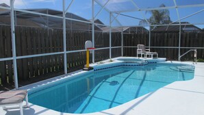 Piscina com toldo, espreguiçadeira e uma pequena banheira de hidromassagem.