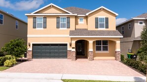 A two-story house with a garage, a front entrance, and a well-maintained lawn. - Encore Resort at Reunion 641 (Kissimmee)