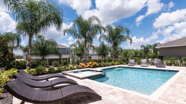 A swimming pool with lounge chairs and palm trees. - Encore Resort at Reunion 641 (Kissimmee)