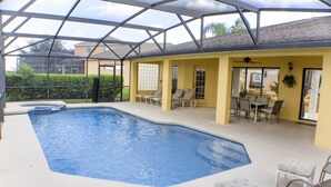 A covered swimming pool area with lounge chairs and a patio table. - Legacy Park The Estates 247 (Davenport)