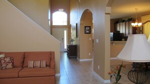 A spacious living area with a sofa, a lamp, and a staircase leading to another room. - Crystal Cove 4730 (Kissimmee)