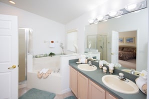 A bathroom with two sinks, a bathtub, and a large mirror. - Thousand Oaks 117 (Davenport)