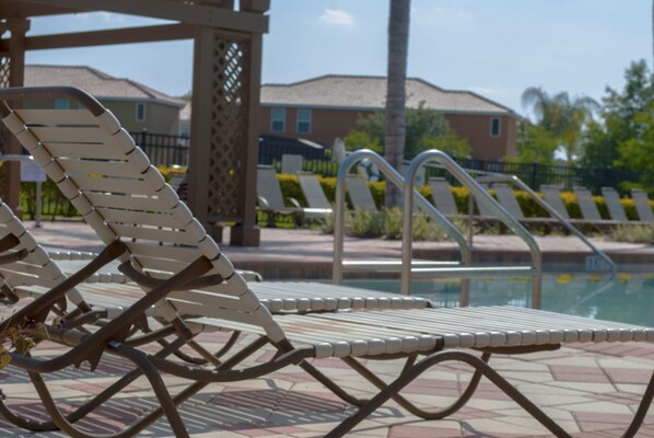 A poolside area with lounge chairs and a pool.