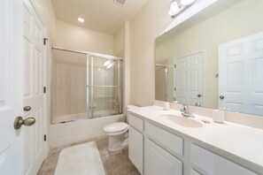 A bathroom with a shower, toilet, sink, and mirror. - Bella Vida 871 (Kissimmee)