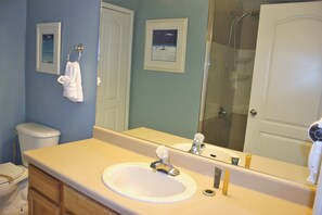 A bathroom with a sink, mirror, and toilet. - Runaway Beach 5008 B11.203 (Kissimmee)