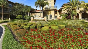 A hotel with a landscaped garden, a sign reading "Bella Piazza," and a stone building with a balcony. - Bella Piazza 904 - 526 (Davenport)