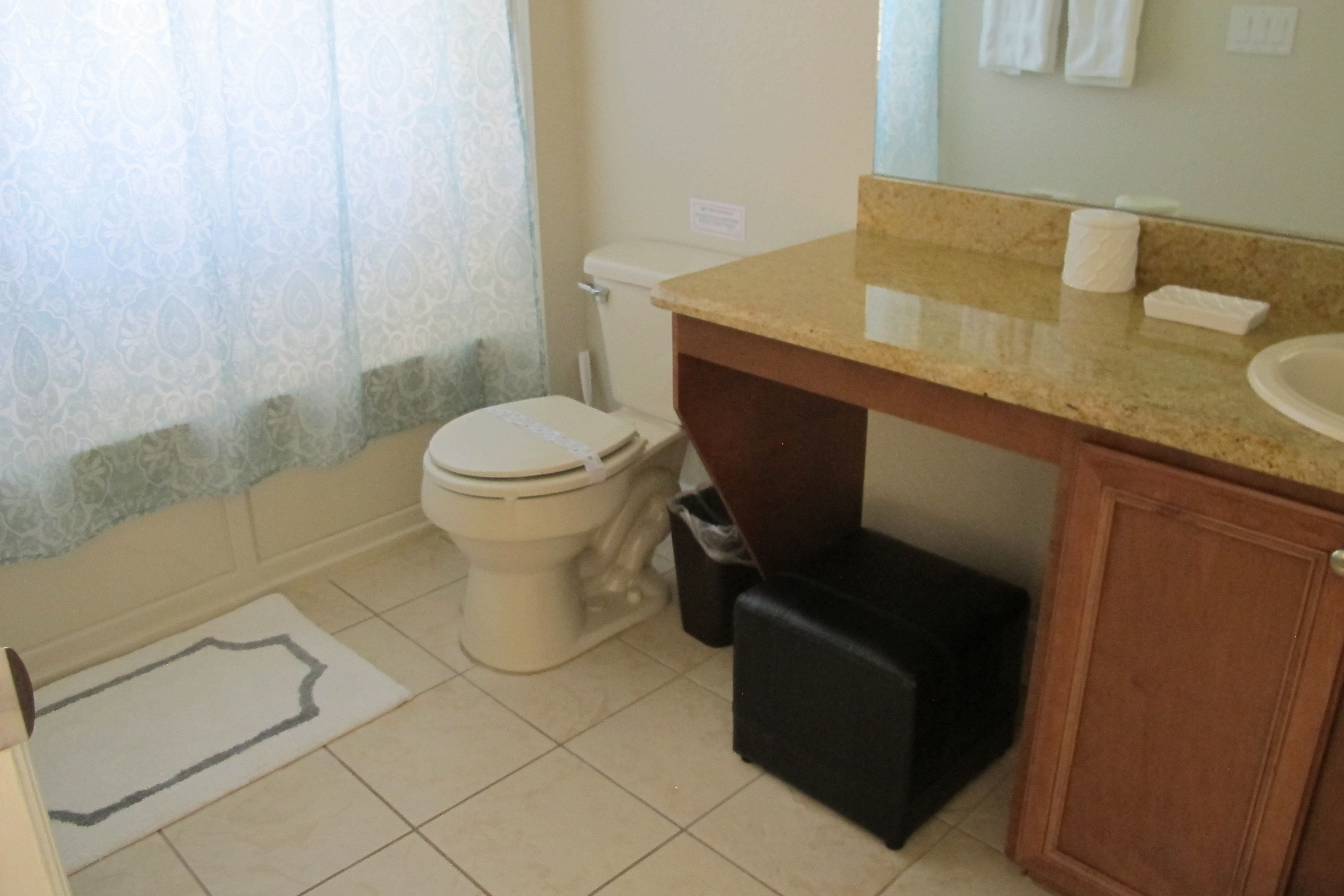 A bathroom with a toilet, sink, and cabinet.