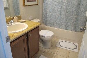 A bathroom with a sink, toilet, and bathtub.