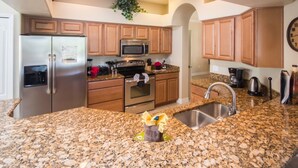 A kitchen with granite countertops, stainless steel appliances, wooden cabinets, and a built-in oven.
