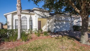 A two-story house with a front yard, a palm tree, and a garage. - High Gate Park 204 (Davenport)
