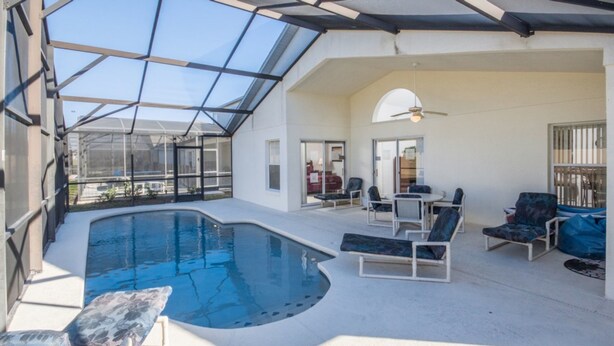 A spacious indoor swimming pool with a glass ceiling, surrounded by lounge chairs and a dining area. - High Gate Park 204 (Davenport)