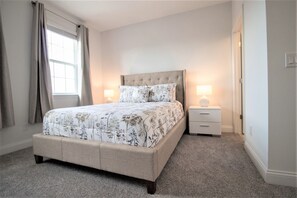 A bedroom with a bed, nightstands, and a window with curtains. - Festival Resort 270 (Davenport)