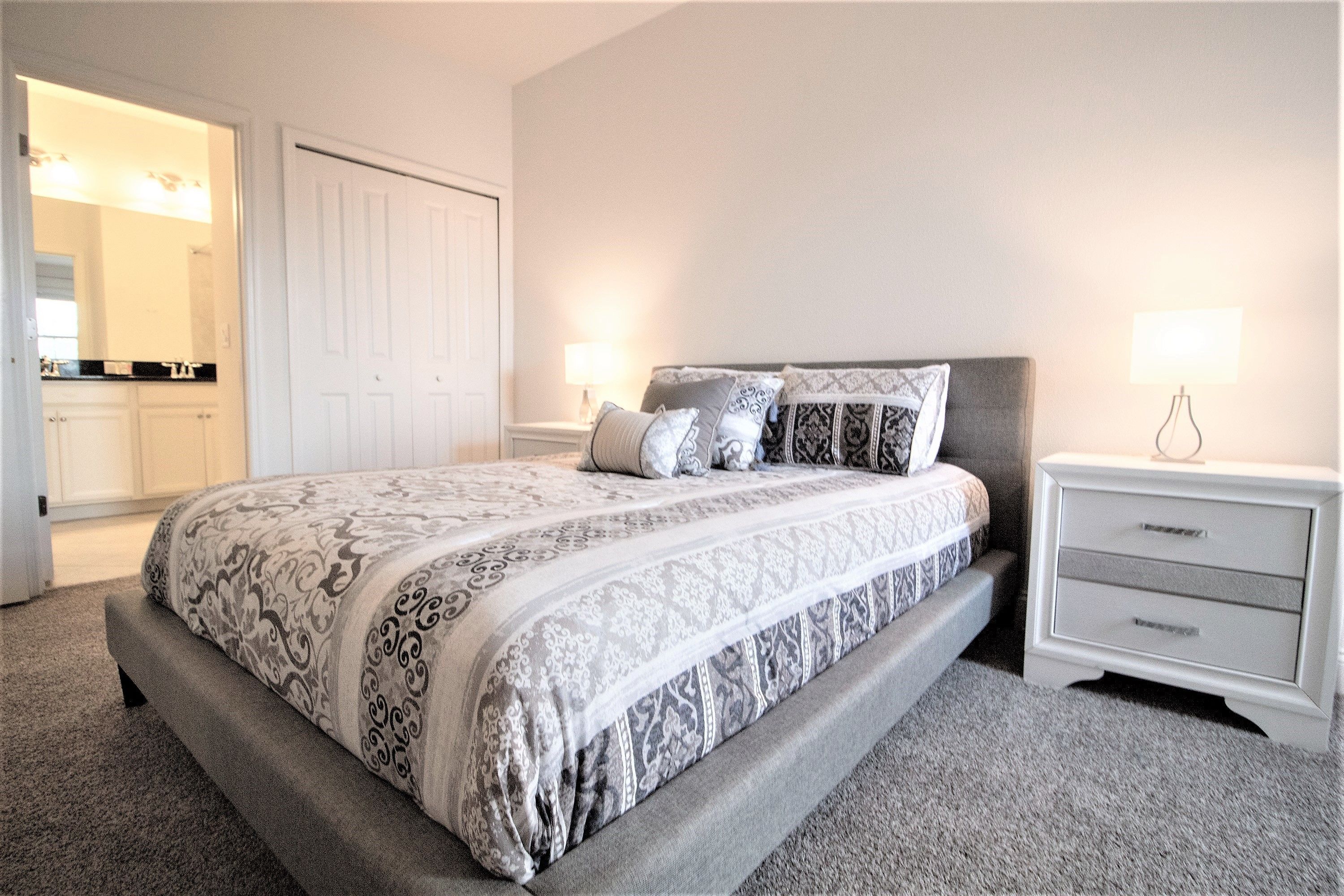 A bedroom with a bed, nightstands, and a dresser.
