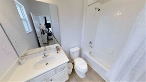 Ein Badezimmer mit Waschbecken, Toilette und Badewanne.