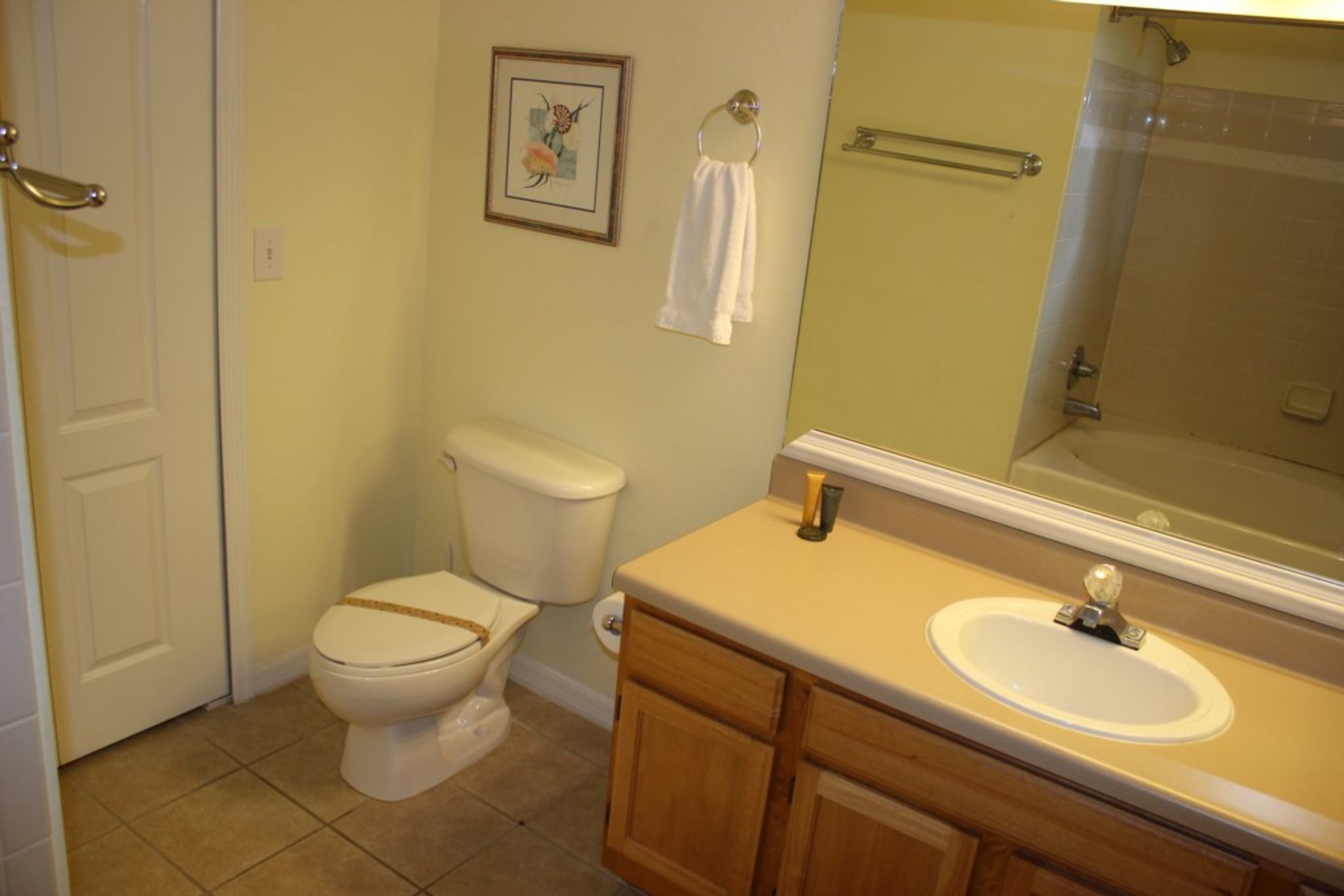 Un bagno con il water, lavandino e specchio.
