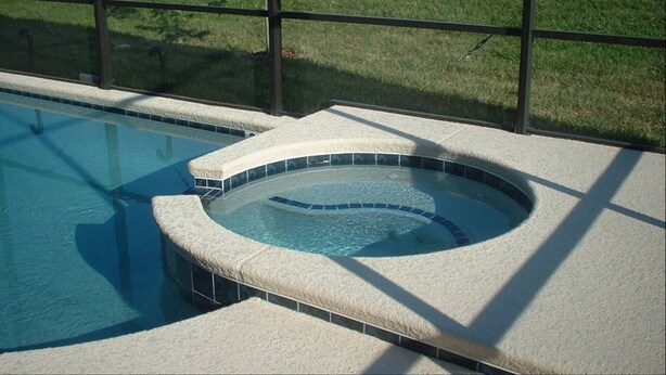 A swimming pool with a hot tub area, surrounded by a glass enclosure. - Emerald Island Resort 8622 (Kissimmee)