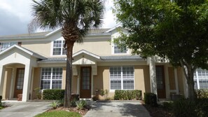 A two-story house with a symmetrical facade, large windows, and a central entrance.